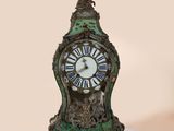 a green clock with roman numerals on the face
