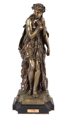 une statue antique en bronze représentant une femme tenant un enfant dans ses bras