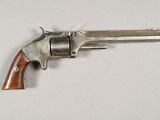 gros plan d'un revolver sur une surface blanche