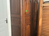 a wooden cabinet in the corner of a room