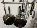 pots and pans hanging on a wall in a kitchen