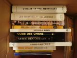 many books stacked on top of each other in a box