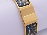 an image of a gold plated bracelet with a blue and yellow design