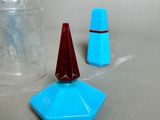 a bottle of liquid next to a blue cone on a table