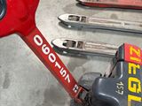 a red and black hand truck with skis and ski poles