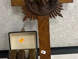 une croix en bois et une boîte de livres posées par terre