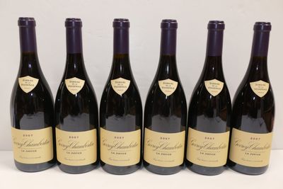 six bouteilles de vin sont alignées sur une table