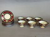 six cups and a saucer and a plate on the table