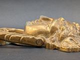 a gold statue of a person laying down on the ground