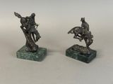 two bronze statues of a man on a horse and a man on a horse