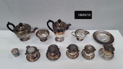 a lot of silver teapots and cups on a table