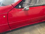 a red car parked in a garage with a bike in the window