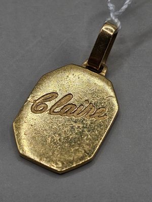 un pendentif plaqué or sur lequel est gravé un prénom