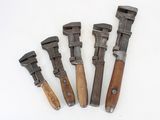 five old tools are lined up in a row on a white surface