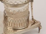 a silver plate with a glass vase on it