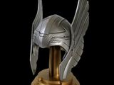 a helmet with wings on top of a gold pedestal
