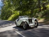 a white vintage car driving down the road in the woods