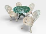 quatre chaises et une table avec un plateau en verre vert