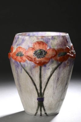 un vase en verre orné de fleurs peintes, posé sur une table