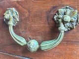 a close up of a brass handle on a wooden cabinet