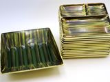 two green and gold square dishes on a white surface