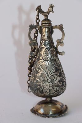 un vase en argent surmonté d'un oiseau