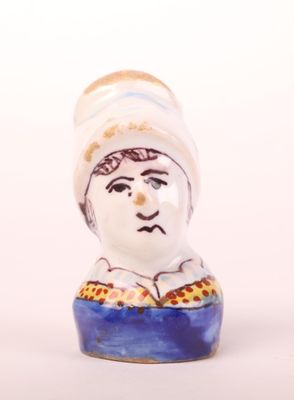 a small ceramic figurine of a man with a hat on