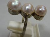 a ring with three pearls on top of it
