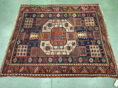 an old rug on the floor with a blue and red design