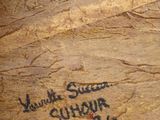 a person holding a piece of wood with writing on it