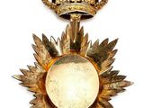 two gold medals with a crown on top of them on a white surface