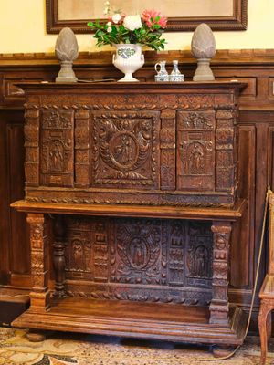une armoire en bois au milieu d'une pièce, sur laquelle est posé un vase