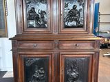 une armoire ancienne en bois, surmontée de panneaux de verre sculptés