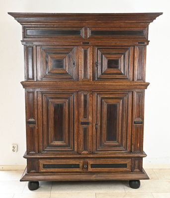 an old wooden cabinet with two doors and a drawer on wheels