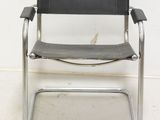 an image of a black leather and chrome chair against a white wall