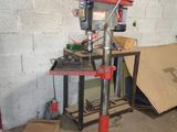 a drill press in a garage with a lot of tools