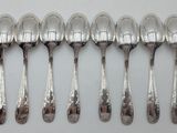 six silver spoons are lined up in a row on a table