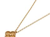 a close up of a gold necklace with a knot on a chain