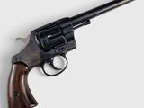 un vieux revolver avec un manche en bois sur fond blanc