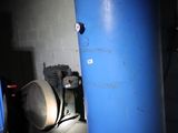 un grand réservoir bleu posé à côté d'une paire de chaussures