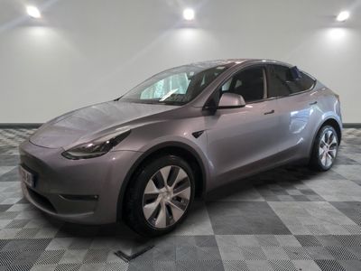 La Tesla Model Y est garée sur un sol en carrelage à damier.