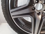 a close up of a car wheel with a tire on a white surface