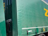un semi-remorque vert garé sur le parking