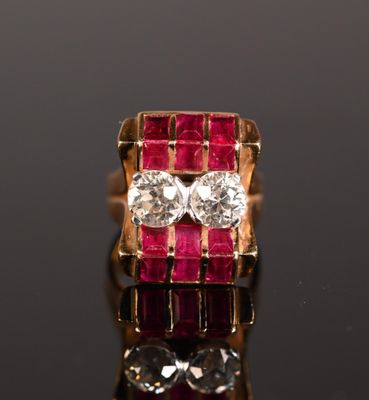 un gros plan d'une bague sertie d'un diamant rouge et blanc sur une surface noire