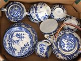 de nombreuses assiettes et tasses bleues et blanches dans une boîte
