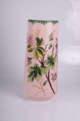 un vase rose orné de fleurs peintes, posé sur une table