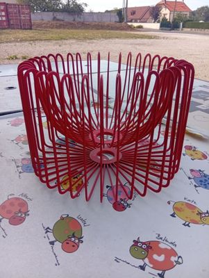 a red wire basket that is sitting on a table