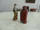 two figurines sitting on a table in a room
