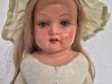 a close up of a doll with a hat on