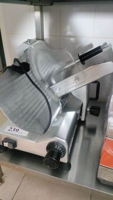 a meat slicer sitting on a counter in a kitchen